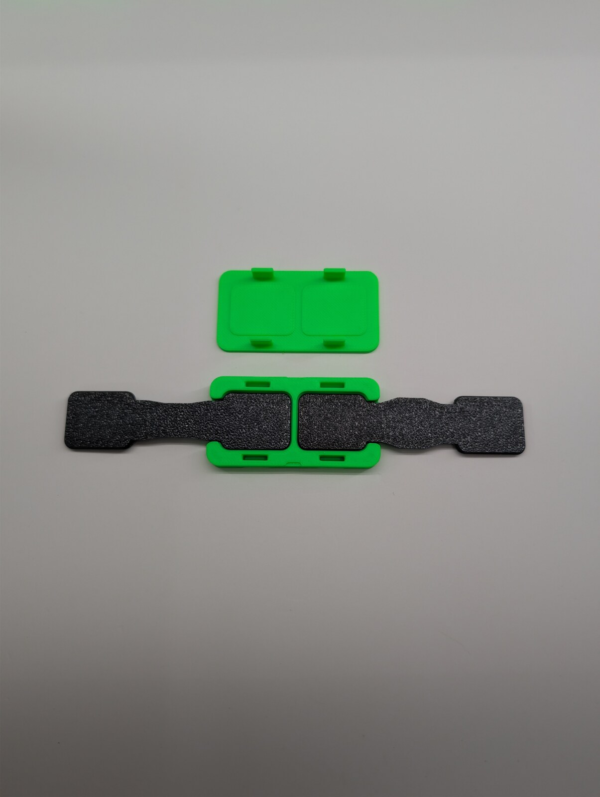 Two straps placed in the open straight joiner with its separate cap above.