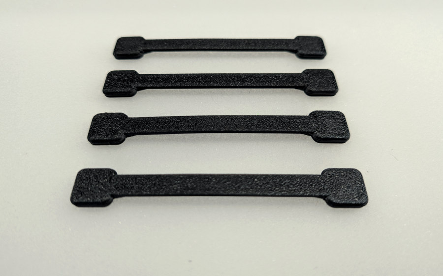 Four real printed Mini straps arranged on a pale background.